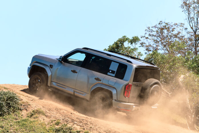 SUV driving up a dusty hill